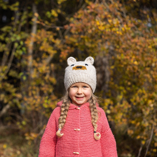Kid wearing Ambler Kuma handknit kids' toque in heather stone with bear ears.