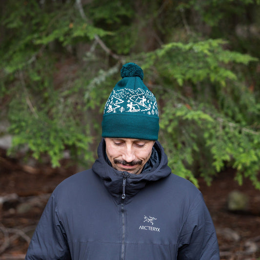 Man wearing made in Canada Ambler Skier machine knit toque in pine with jacquard design and fold up cuff.