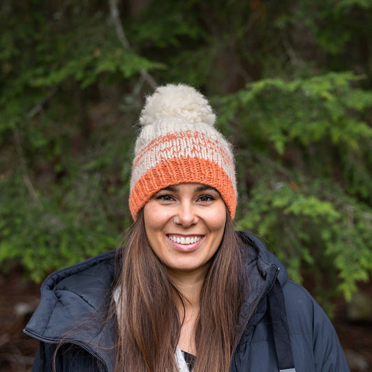 Woman wearing Ambler Wren handknit women's toque in gelato with ribbed cuff and medium pom.