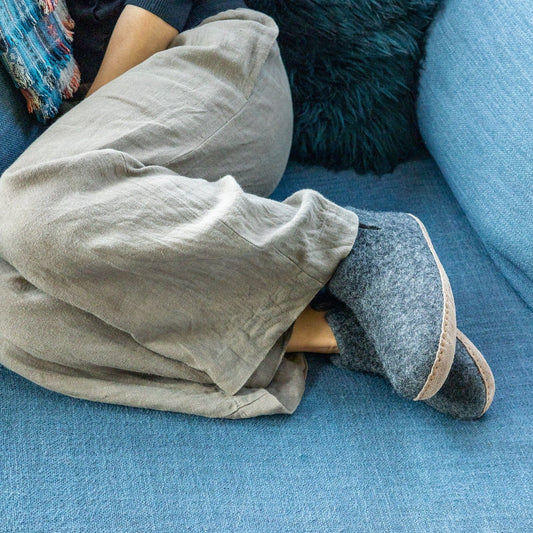 Person wearing a pair of Ambler Carlyle wool felt slipper boots in heather charcoal. 