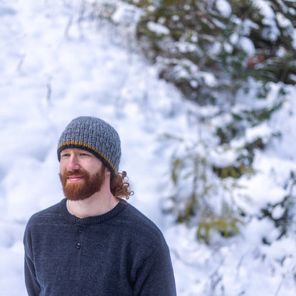Man wearing Ambler Andrew handknit men's toque in heather grey. 