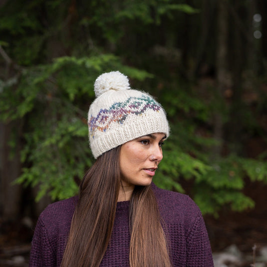 Woman wearing Ambler Anne handknit women's toque in natural with jacquard design and ribbed cuff. 