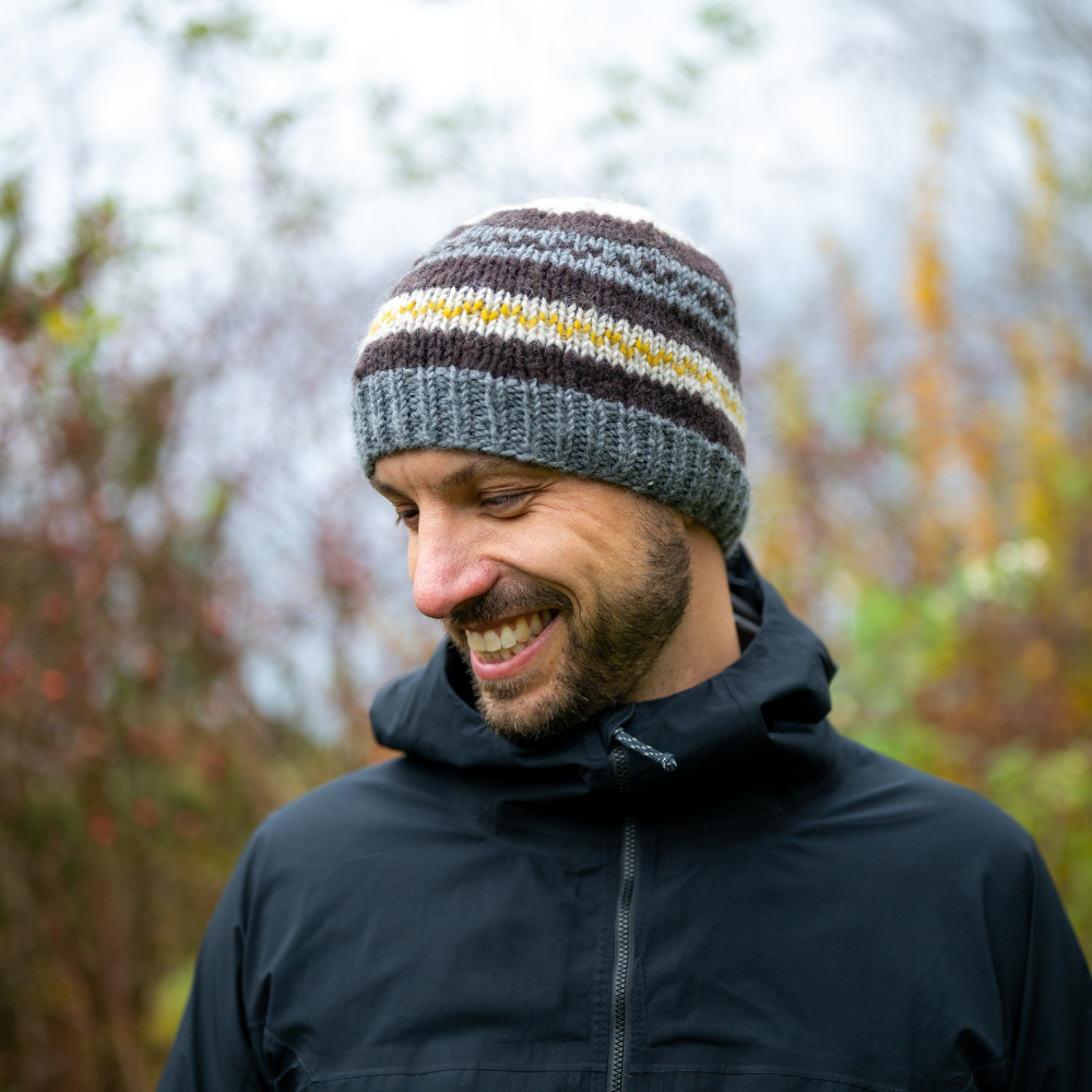 Man wearing Ambler Atlas handknit men's toque in heather grey with ribbed cuff and fleece headband lining. 