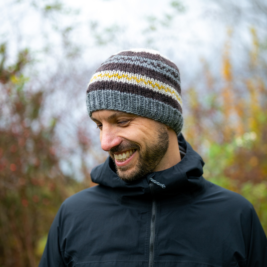 Man wearing Ambler Atlas handknit men's toque in heather grey with ribbed cuff and fleece headband lining. 