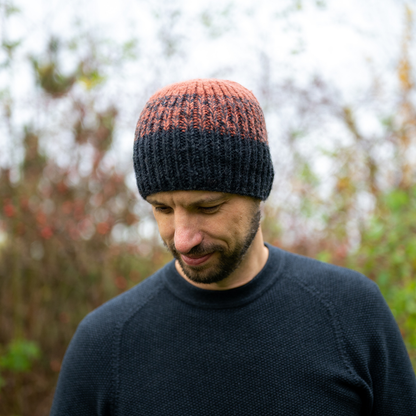 Man wearing Ambler Cypress handknit men's toque in heather charcoal with tri-colour ribbed pattern. 