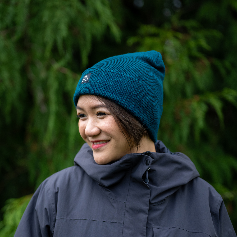 Woman wearing Made in Canada Ambler Frank machine knit toque in pine with Ambler logo patch. 