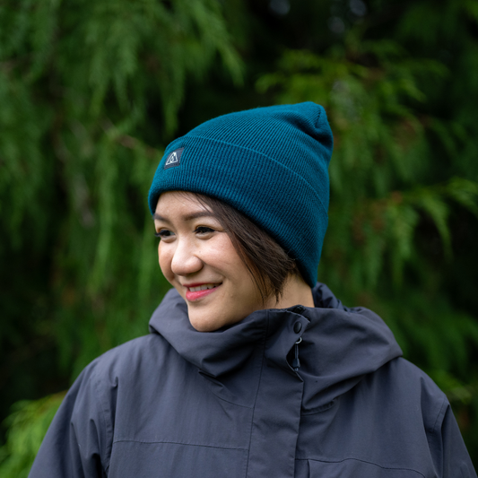 Woman wearing Made in Canada Ambler Frank machine knit toque in pine with Ambler logo patch. 