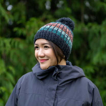 Woman wearing Ambler Kori handknit wool toque in heather charcoal with checkered design. 