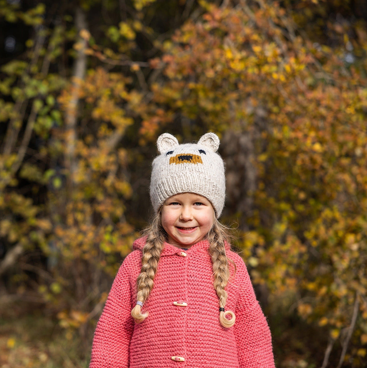 Kid wearing Ambler Kuma handknit kids' toque in heather stone with bear ears. 