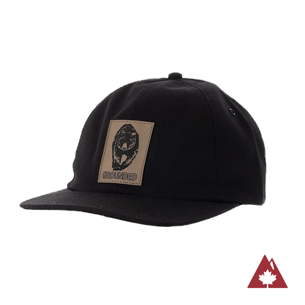 Black snapback cap with a patch on the front panel of a bear. 