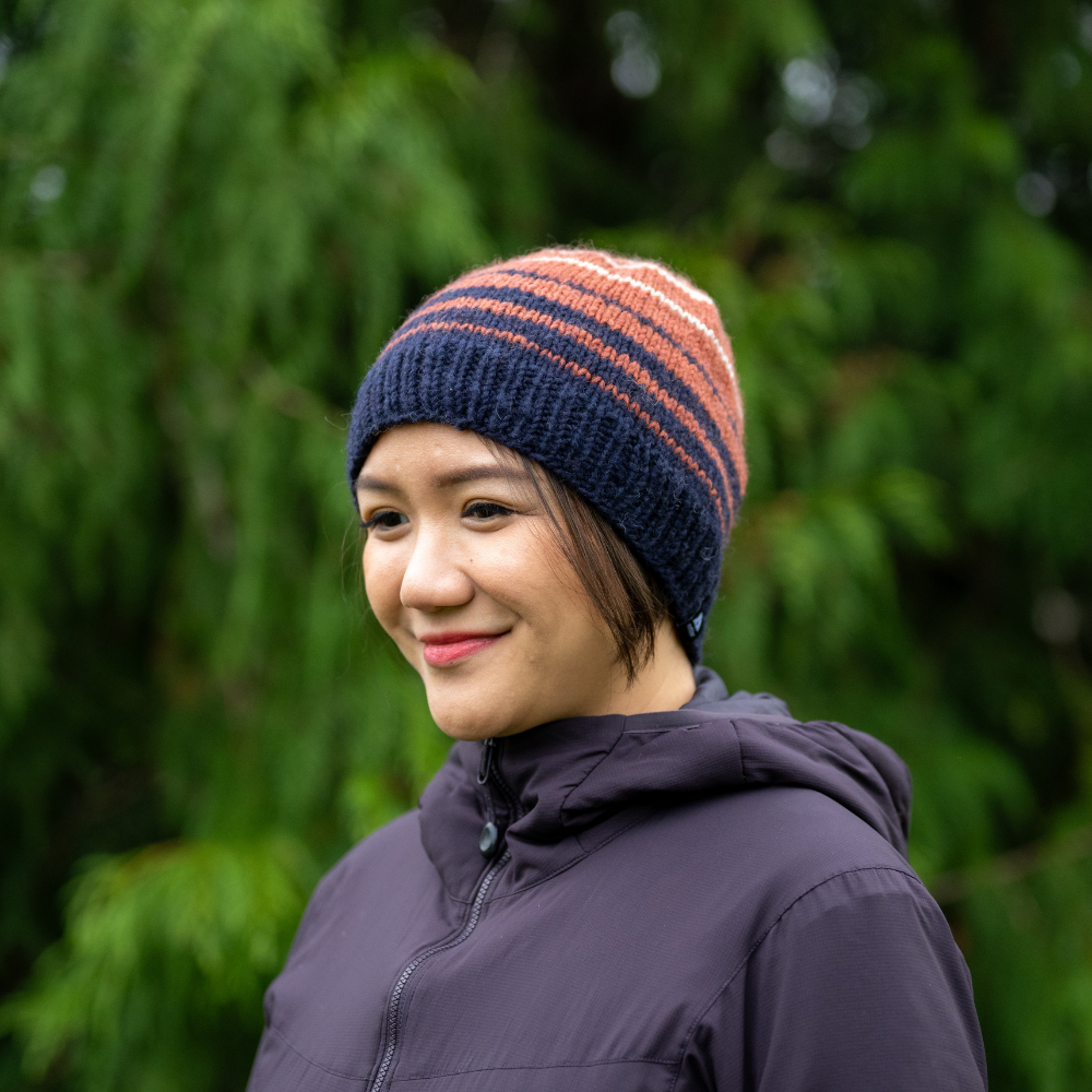 Woman wearing Ambler Ollie handknit wool men's toque in midnight with striped design and warm ribbed cuff. 