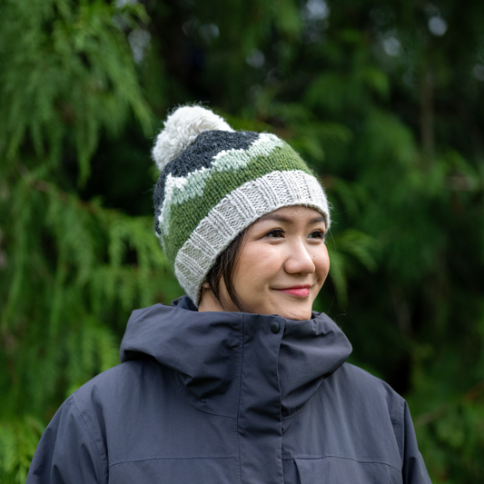 Woman wearing Ambler Purcell handknit toque in heather stone with mountain jacquard design and ribbed band. 