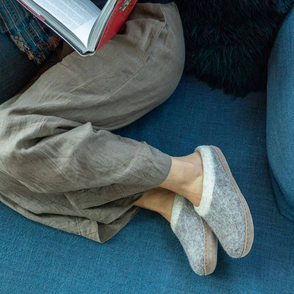 Person wearing Ambler Slocan wool slippers in heather grey with natural leather sole - cozy indoor footwear. 