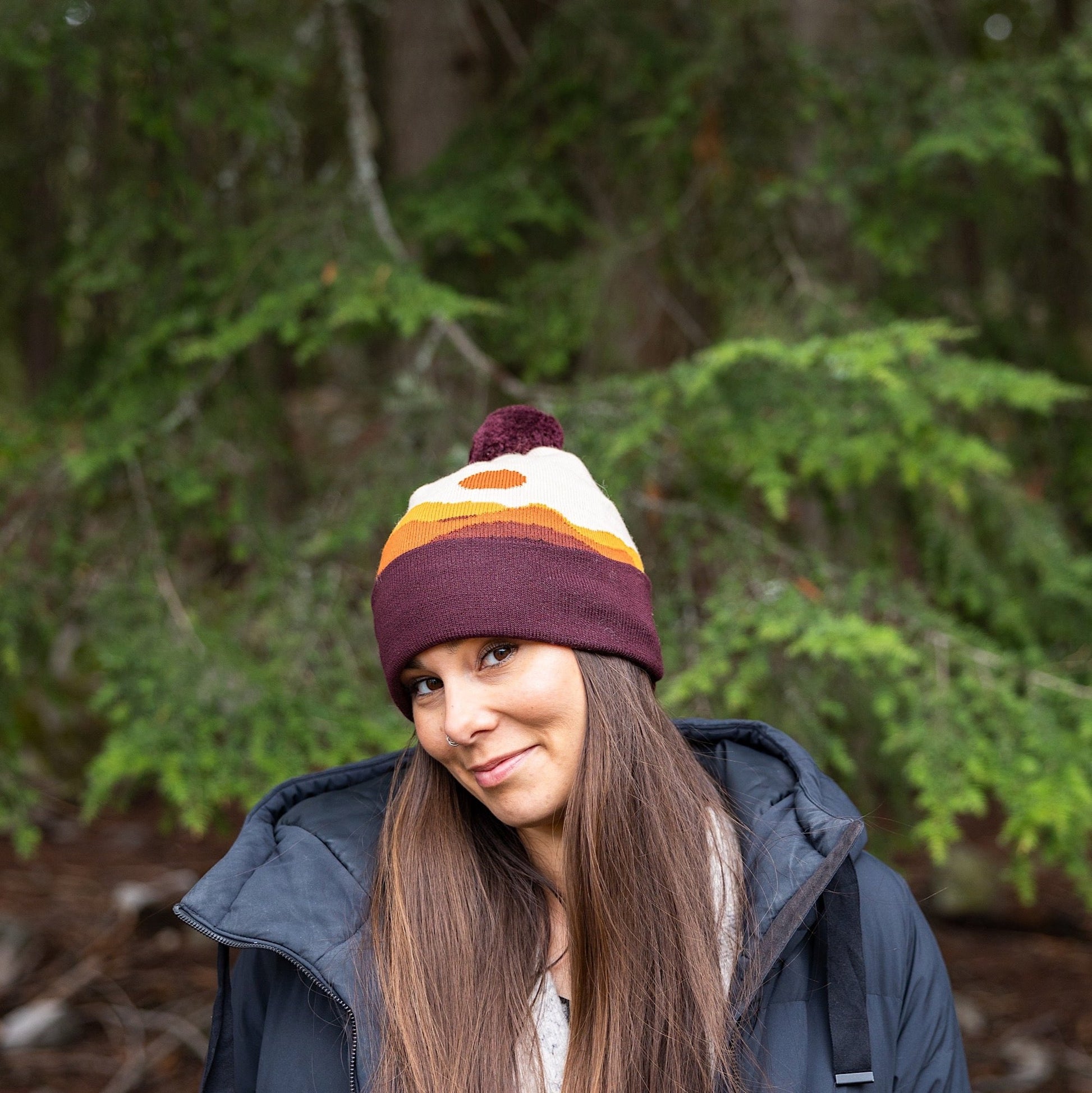 Woman wearing Made in Canada Ambler Sunset machine knit toque in merlot.