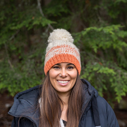 Woman wearing Ambler Wren handknit women's toque in gelato with ribbed cuff and medium pom. 