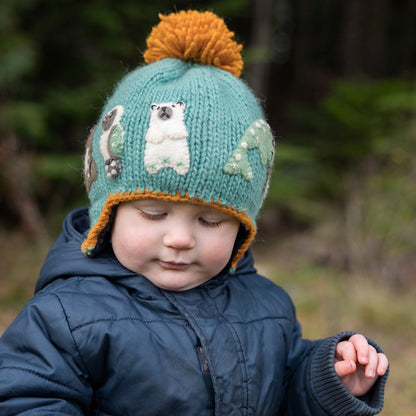Toddler wearingAmbler Yeti handknit kids' toque with felted creatures and medium pom. 